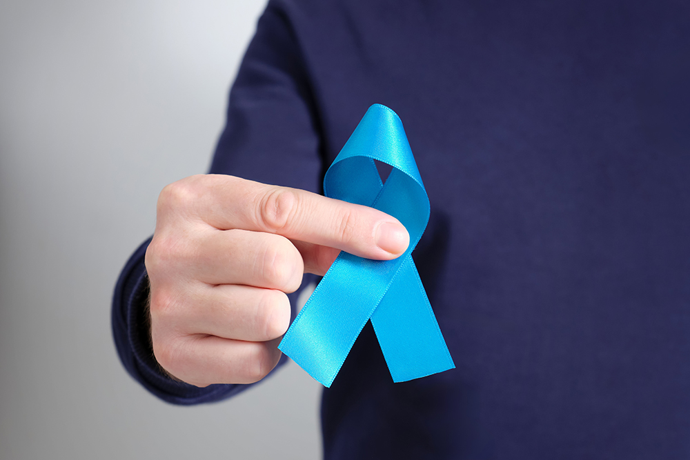 homem segurando laço azul símbolo de prevenção ao câncer de próstata no novembro azul