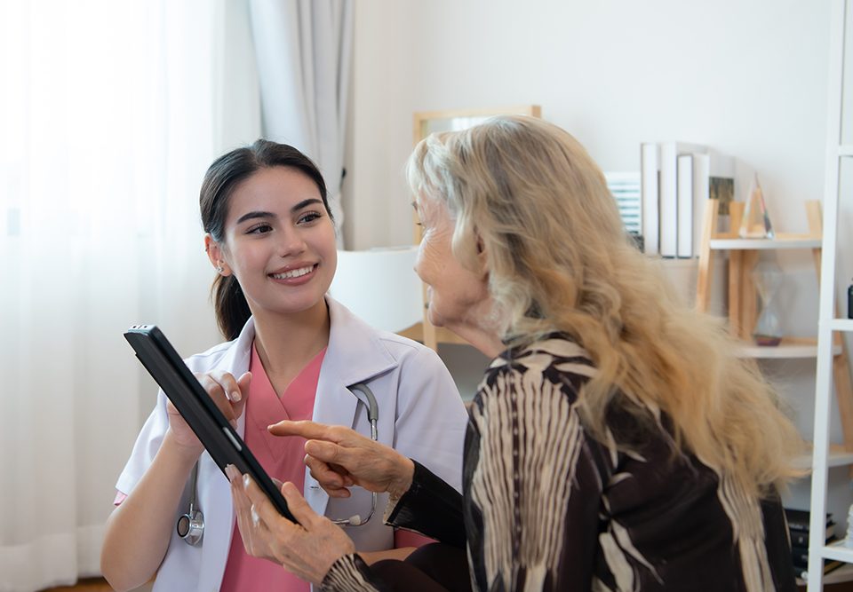 Cuidadora de uma mulher idosa faz exames semanais na residência da paciente.