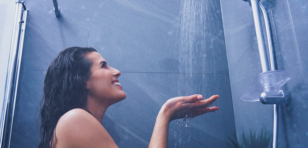Mulher adulta debaixo do chuveiro no banheiro