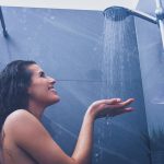 Mulher adulta debaixo do chuveiro no banheiro