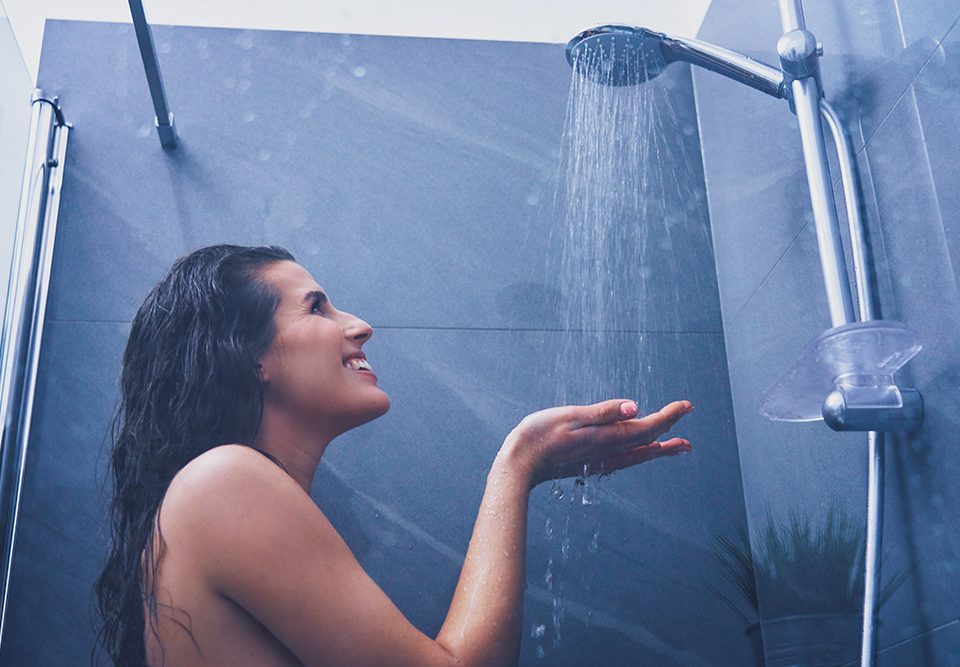 Mulher adulta debaixo do chuveiro no banheiro
