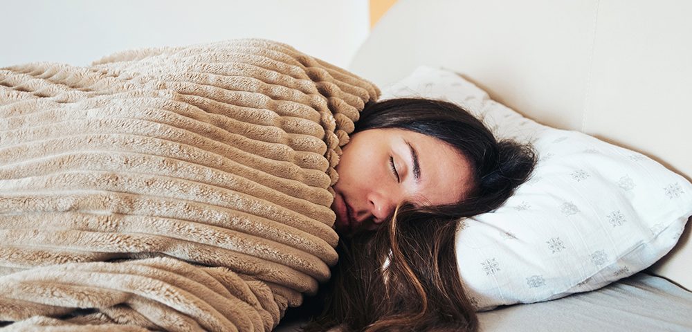Mulher dormindo em sua cama.
