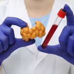 Endocrinologista mostrando modelo de glândula tireoide e amostra de sangue em tubo de ensaio.