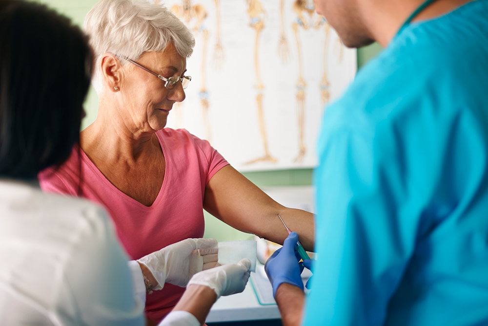 Exame médico de sangue realizado por pessoal médico.